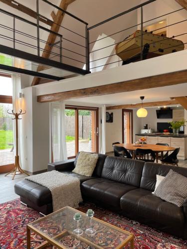 un salon avec un canapé en cuir noir et une table dans l'établissement l'héberge des Argales, à Vred