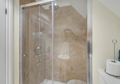 a shower with a glass door in a bathroom at Pebblesea in Whitstable