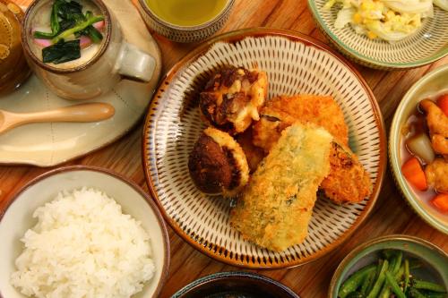 a table with plates of food with rice and vegetables at ほうしゅ楽舎 in Asakura