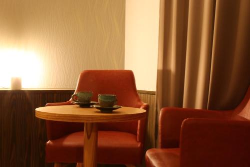 a chair and a table with two cups on it at ほうしゅ楽舎 in Asakura