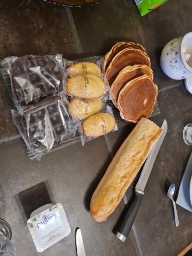 uma mesa coberta com pão e uma faca e palitos de pão em Chez Malia em Saint-Nicolas-des-Motets