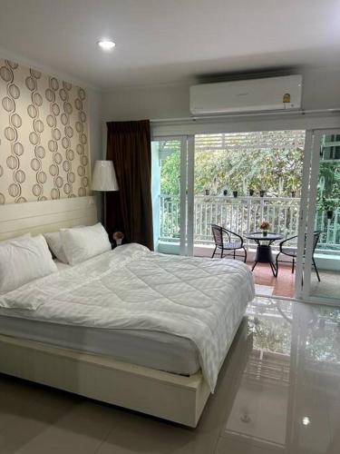 a bedroom with a large bed and a balcony at Baan Klang Condo in Central Hua Hin in Hua Hin