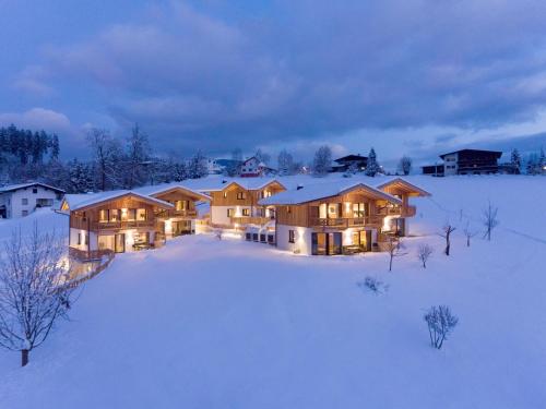 a house in the snow at night with lights on at Chalet in Mariastein Hohe Salve with mountain view in Mariastein