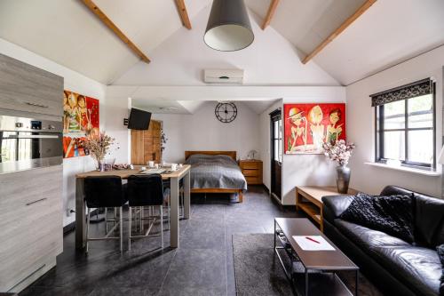 a living room with a bed and a dining room at Brabants Genieten in Kaatsheuvel