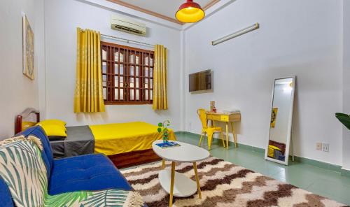 a bedroom with a yellow bed and a table at Feli Home 1 - Close to Landmark 81 in Ho Chi Minh City