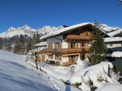 a log cabin in the snow with mountains in the background at Scenic Apartment in Maria Alm near Ski Lift in Maria Alm am Steinernen Meer