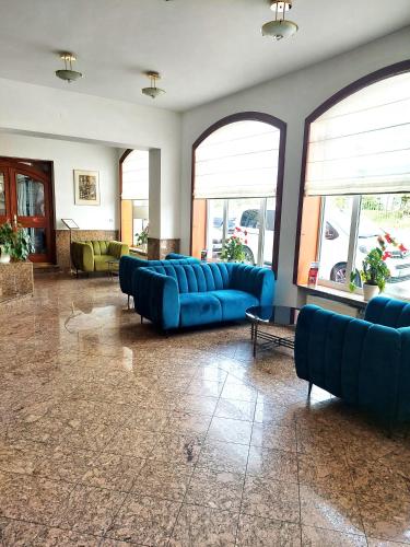 a large living room with blue couches and windows at Hotel Avion in Prague