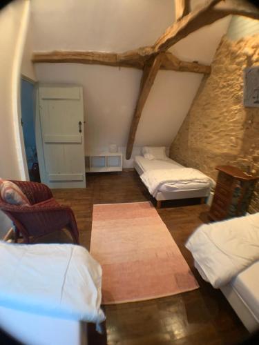 une chambre mansardée avec deux lits et une table dans l'établissement La Renardière Chez Jeanne Gîte 5/7 personnes. Piscine, à Paunat