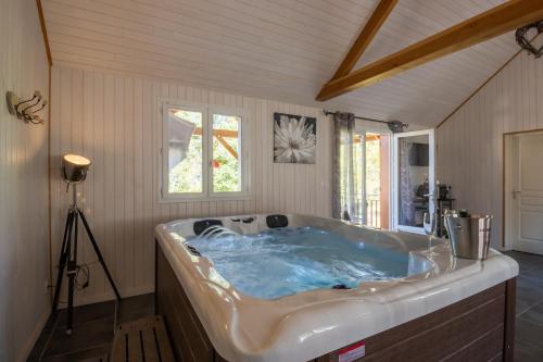 een groot bad in een kamer met een raam bij CHALET DU REV'EAUBOIS in Larche