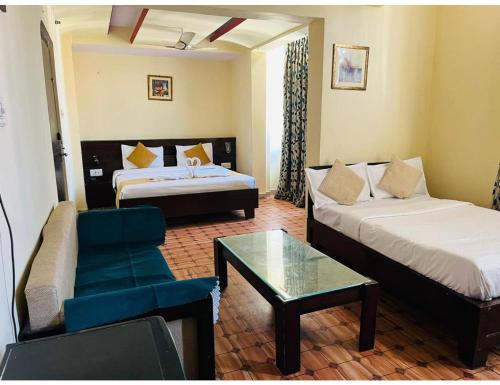 ジャイプールにあるHotel Maziz Prime, Jaipurのベッド、ソファ、テーブルが備わるホテルルームです。