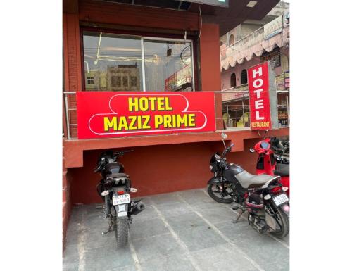 ジャイプールにあるHotel Maziz Prime, Jaipurのホテルの市場のプライムサインの前に駐車したオートバイ2台
