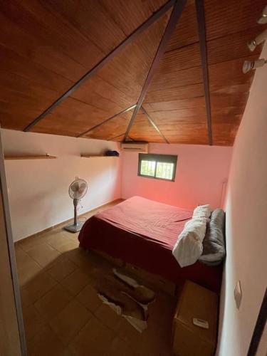 una camera con letto rosso e soffitto in legno di Art residency Lagoon a Siviglia