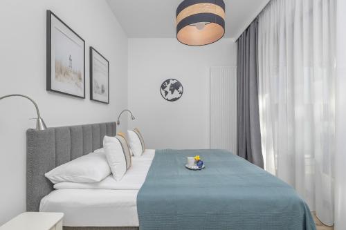 a bedroom with a bed with a blue blanket at Apartament Relax z Balkonem Shellter Rogowo Renters Prestige in Rogowo