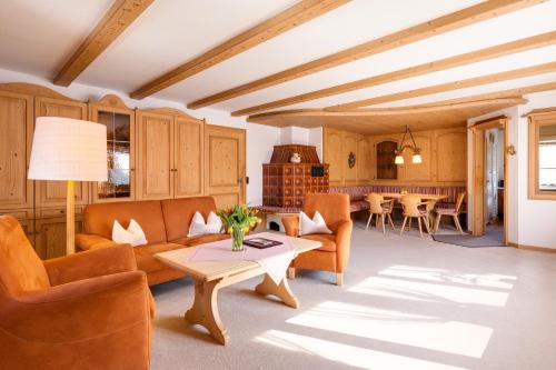 a living room with orange furniture and a table at Hotel Bergfried & Schönblick in Bad Reichenhall