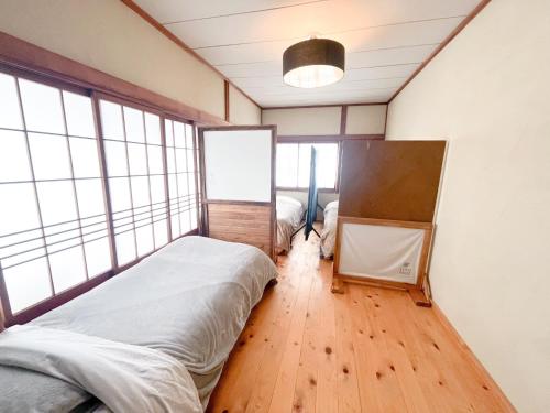 a bedroom with a bed in a room with windows at Dormitory SLOW HOUSE Kesennuma- Vacation STAY 30914v in Kesennuma