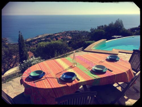 una mesa con tazones y platos junto a una piscina en Villa with DREAM VIEW and SWIMMING POOL!!, en Les Issambres