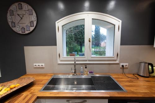 een keuken met een wastafel en een raam bij Villa Le Blavet in Puget-sur Argens