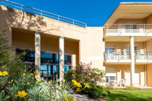 Nemea Appart Hotel Green Side Biot Sophia Antipolis في بيوت: مبنى مكتب أمامه زهور