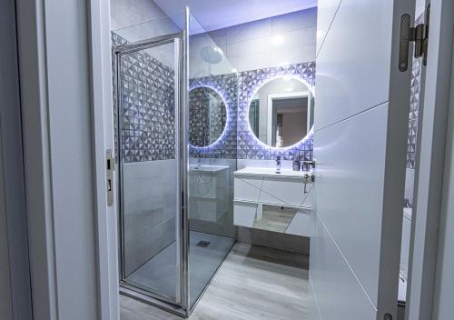 a bathroom with a shower and a sink and a mirror at Casa Sol e Areia Villa Eira Nova in Porto Covo