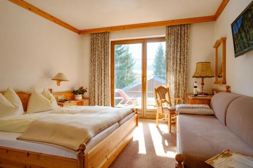 a bedroom with a bed and a large window at Waldpension Putz in Berg im Drautal