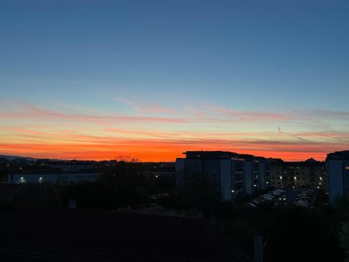 a sunset over a city with buildings in the foreground at Urban Sunset Apartment in Sibiu