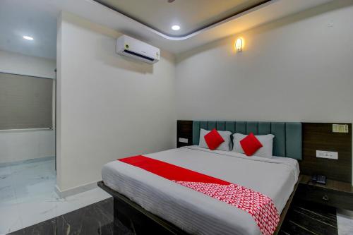 um quarto com uma cama grande e almofadas vermelhas em BHILVA INN em Warangal