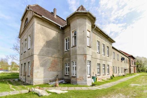 an old stone building with a roof at Gutsherrenwohnung in Süderholz