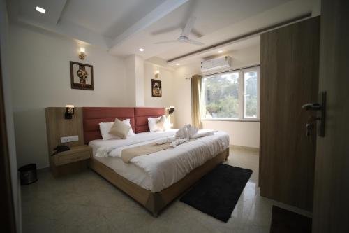 Un dormitorio con una cama grande y una ventana en The Countryside, en Dehradun