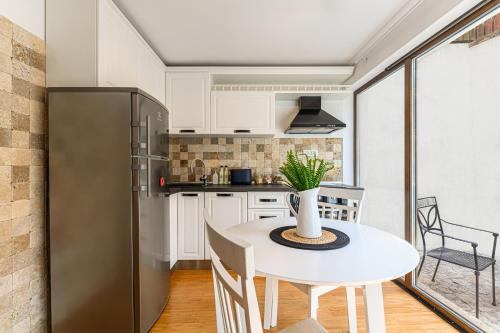 a kitchen with a white table and a refrigerator at Ceahlau Cozy House in Braşov