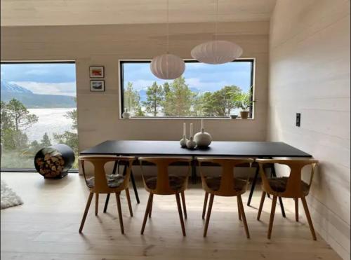 a dining room with a black table and chairs at Ny hytte i Malangen in Nordby