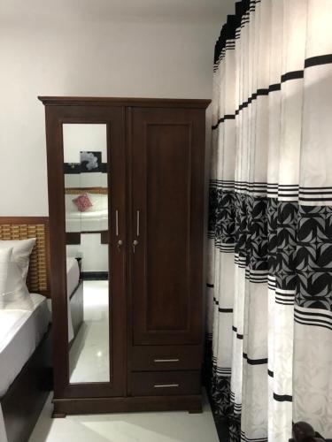 a bedroom with a wooden cabinet with a window at BRICK VILLA in Ahangama