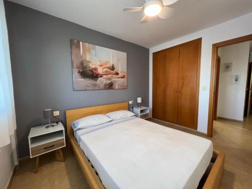 een slaapkamer met een bed en een schilderij aan de muur bij Apartamento Segrelles 22 in Canet de Berenguer