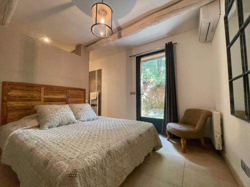 une chambre avec un lit, une chaise et une fenêtre dans l'établissement LE MAS 5 étoiles SPA Saint Quenin-26 personnes- Accueil Familles et événements MONT VENTOUX PROVENCE, à Saint-Romain-en-Viennois