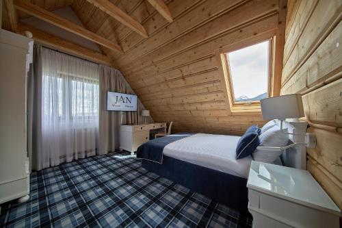 sypialnia z łóżkiem w drewnianym domku w obiekcie New Willa Jan w Zakopanem