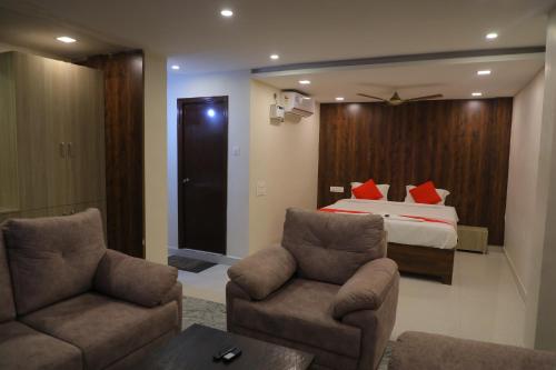 Habitación de hotel con 1 cama y 2 sillas en Nakshatra grand, en Tirupati