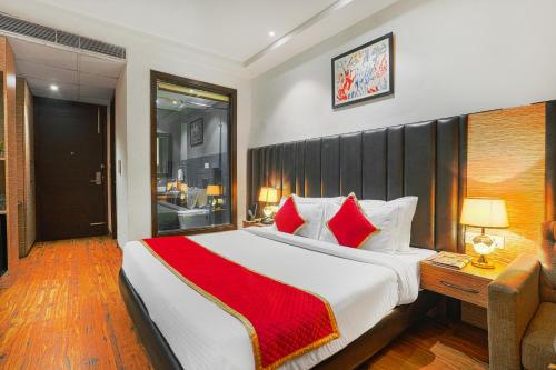 a bedroom with a large bed with red pillows at Pax The Mustard Inn in Amritsar