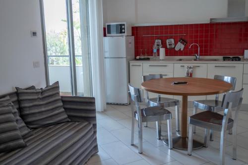 a kitchen with a table and chairs and a couch at Sikelika Residence Sul Mare in Scoglitti