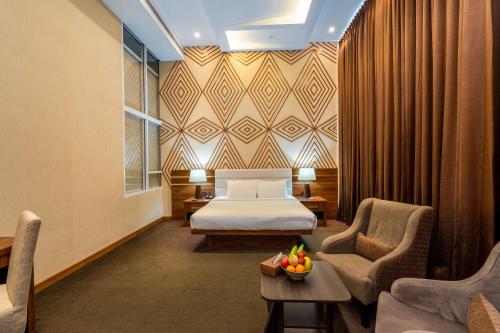 Habitación de hotel con cama, sillas y mesa en The Epitome en Kurunegala