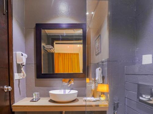 een badkamer met een wastafel en een spiegel bij Pax The Mustard Inn in Amritsar