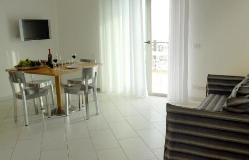 a dining room with a table and chairs and a television at Sikelika Residence Sul Mare in Scoglitti