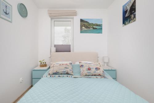 ein Schlafzimmer mit einem Bett mit zwei Kissen darauf in der Unterkunft Feniks SPA Apartments 10 by Jantar Apartamenty Kołobrzeg in Kołobrzeg