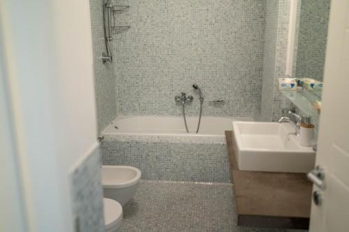 a bathroom with a tub and a toilet and a sink at Sikelika Residence Sul Mare in Scoglitti