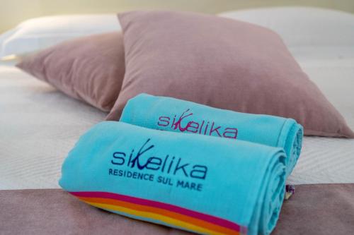a pillow sitting on top of a bed at Sikelika Residence Sul Mare in Scoglitti