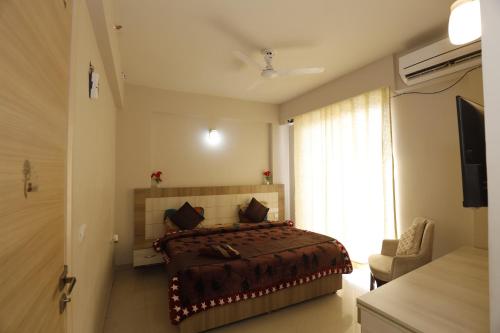 a bedroom with a bed and a large window at The Grand View Studio in Vrindāvan