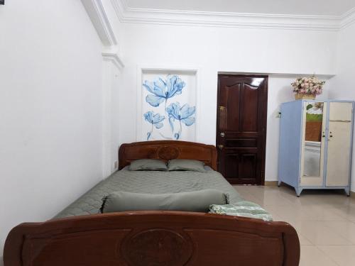 Schlafzimmer mit einem Bett und einem Kühlschrank in der Unterkunft Home Tea An Yên 3 in Ho-Chi-Minh-Stadt