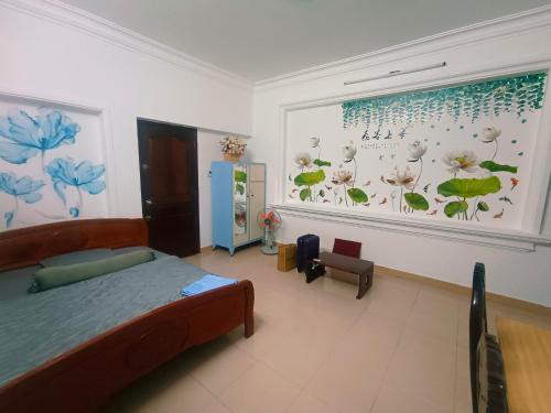 ein Schlafzimmer mit einem Bett und einem Fenster mit Blumen an der Wand in der Unterkunft Home Tea An Yên 3 in Ho-Chi-Minh-Stadt