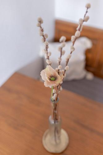 a glass vase with flowers on a table at Bed and Breakfast Mili Vrh in Kamnik