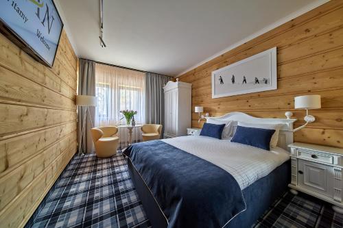 a bedroom with a large bed and wooden walls at New Willa Jan in Zakopane
