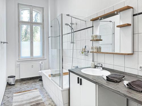biała łazienka z umywalką i prysznicem w obiekcie Ferienwohnung Villa Nieske - Jugendstil Denkmal w mieście Herzberg