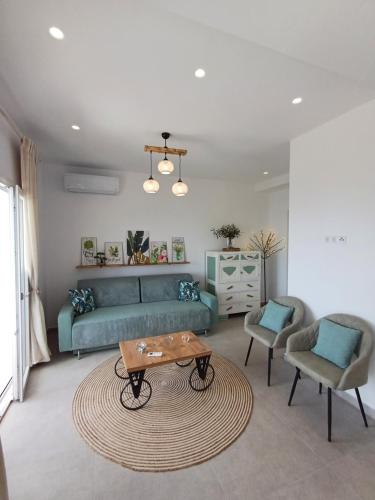 a living room with a blue couch and a table at Villa Filothea with Jacuzzi and sea view in Spartýlas